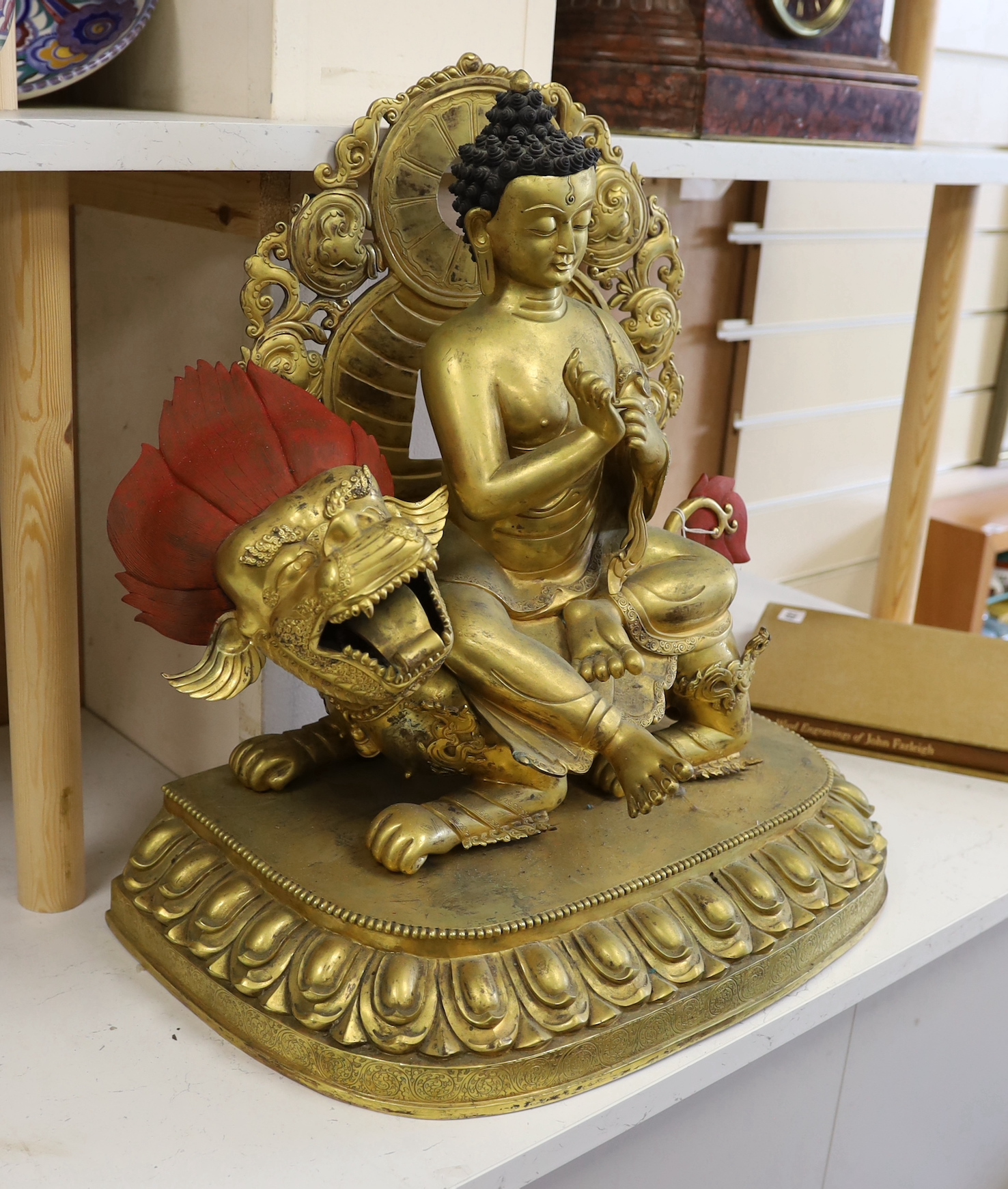 A massive Sino-Tibetan gilt bronze figure of Buddha seated on a lion, 51cm tall